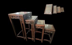 Oriental Style Nest of Four Tables, stained beech wood, all with glass tops, carved fronts.