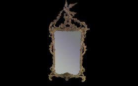 Large Rococo Gilt Framed Mirror. Decorative bird filial and extensive scrolling to mirror edges.