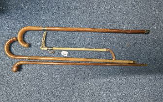 Three Traditional Gentlemen's Walking Sticks, together with a riding crop with a bone handle.