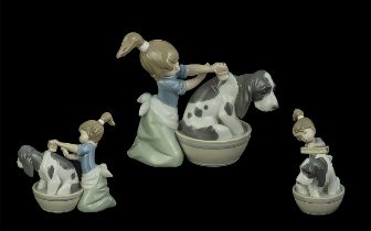 A Lladro figure Bashful Bather, No. 5455, with a young girl washing a dog in a tub, measures 5''