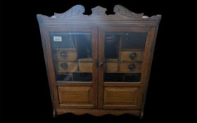 Wall Mounted Tobacco Cabinet in Oak, two bevelled glass doors with compartments and tobacco jars. 56