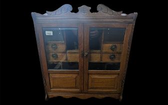 Wall Mounted Tobacco Cabinet in Oak, two bevelled glass doors with compartments and tobacco jars. 56
