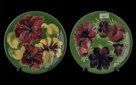 Two Moorcroft Plates, 10'' diameter, one dark green with Hibiscus pattern, one dark green with