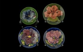 Moorcroft Collection comprising three 4.5'' pin dishes, Hibiscus pattern, Clematis pattern, and