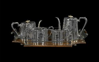 Plated Ware Tea Service, comprising teapot, hot water/coffee pot, milk jug and sugar bowl, on an oak