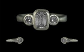Platinum & Diamond Ring, set with an emerald cut centre stone with two round brilliant cut, fully