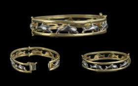 14ct Gold - Pleasing Two Tone Dolphins Design Hinged Bangle. Marked 14ct. Set with Figural Image