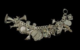A Superior Quality Sterling Silver Charm Bracelet - Loaded with Approx 30 Silver Charms. Bracelet