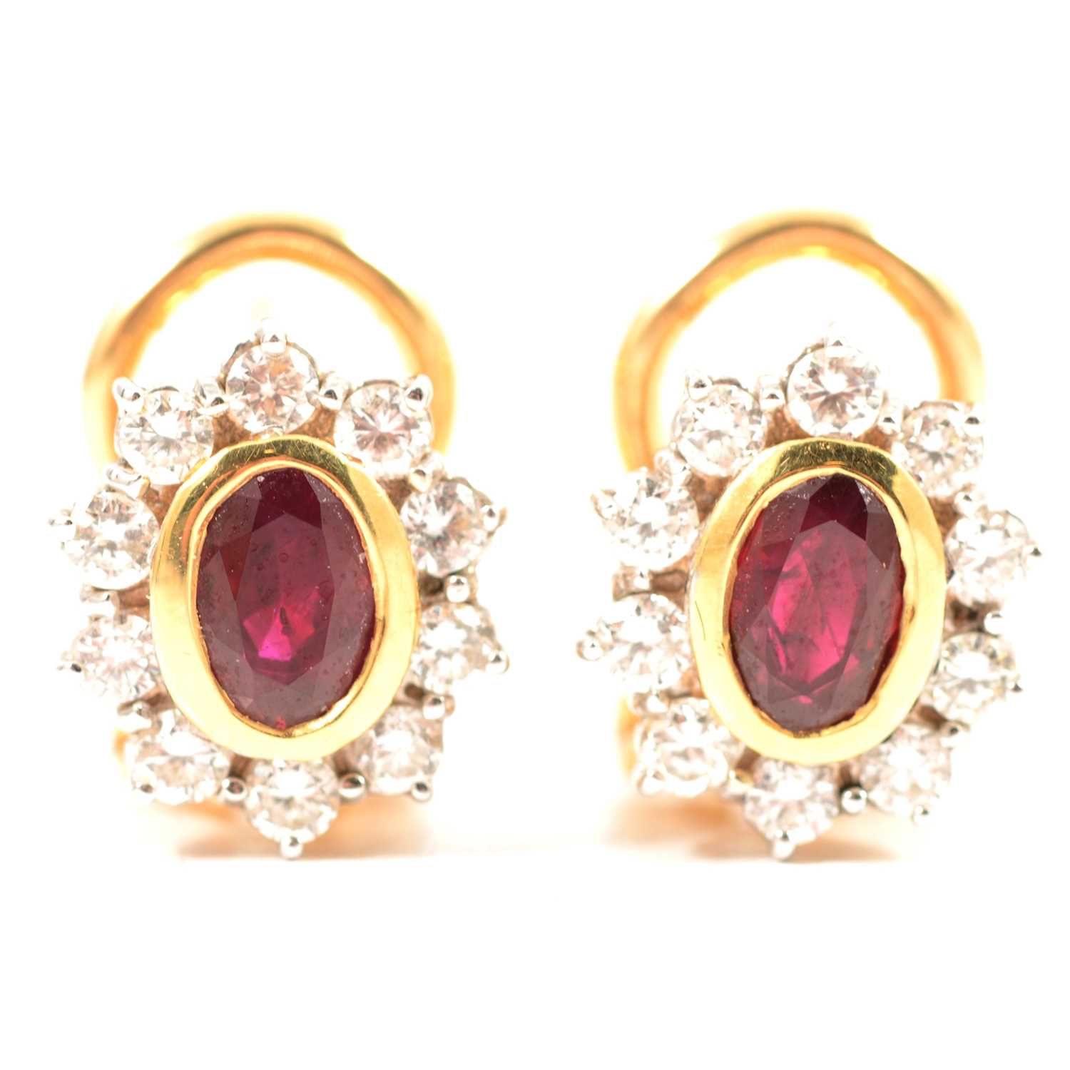 A pair of ruby and diamond oval cluster earrings.