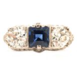 Ellis Bros - A sapphire and diamond three stone ring in diamond set mount.