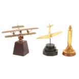 Trench art shell case cigarette lighter and two brass models of aeroplanes.