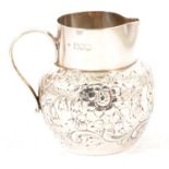 A silver cream jug by Charles Edwards.