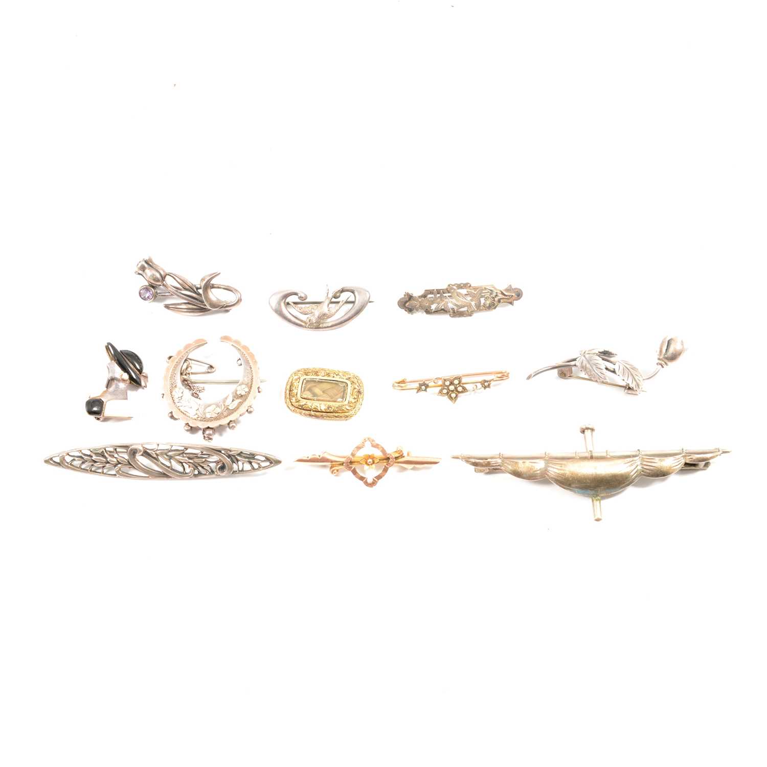 A collection of Victorian and later silver and gold brooches.