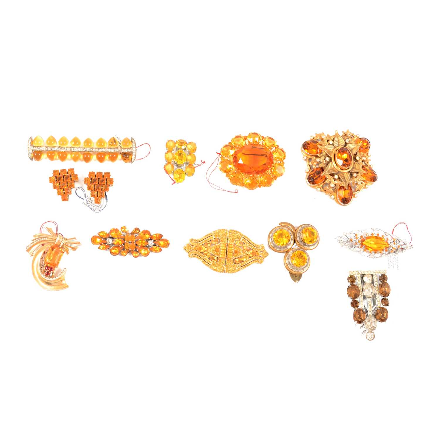 Twelve Art Deco and later faux topaz paste dress clips and brooches.