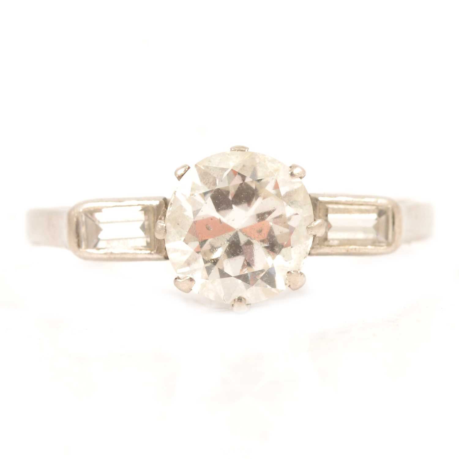 A diamond solitaire ring with baguette cut shoulders.