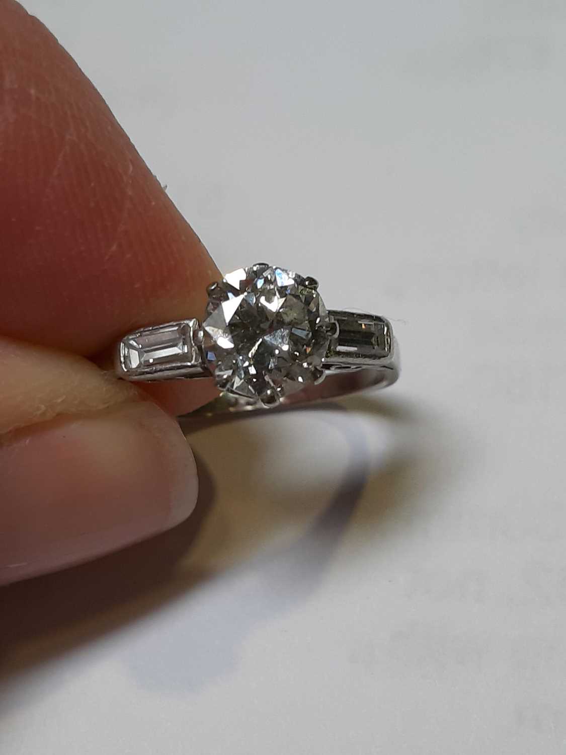 A diamond solitaire ring with baguette cut shoulders. - Image 2 of 7