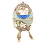 20th century Russian enamelled silver egg shaped trinket pot raised on three hoof legs.