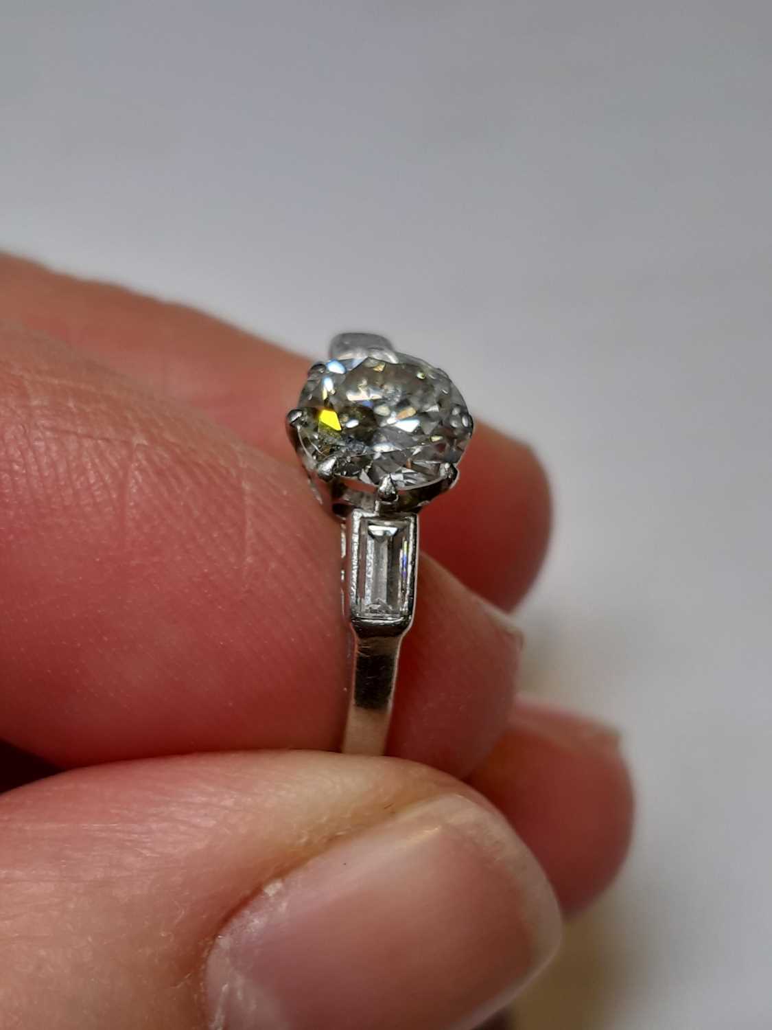 A diamond solitaire ring with baguette cut shoulders. - Image 4 of 7