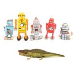 Five tin-plate clock-work retro robot toys, and a crocodile.