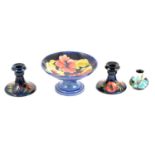 Moorcroft Pottery - pair of Poppy pattern dwarf candlesticks, Hibiscus comport and miniature vase.