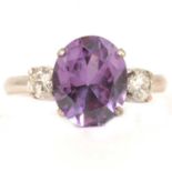 A purple synthetic corundum and diamond three stone ring.