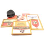 Quantity of framed WWII banners, a Communist-era banner, German Luftwaffe service cap, etc