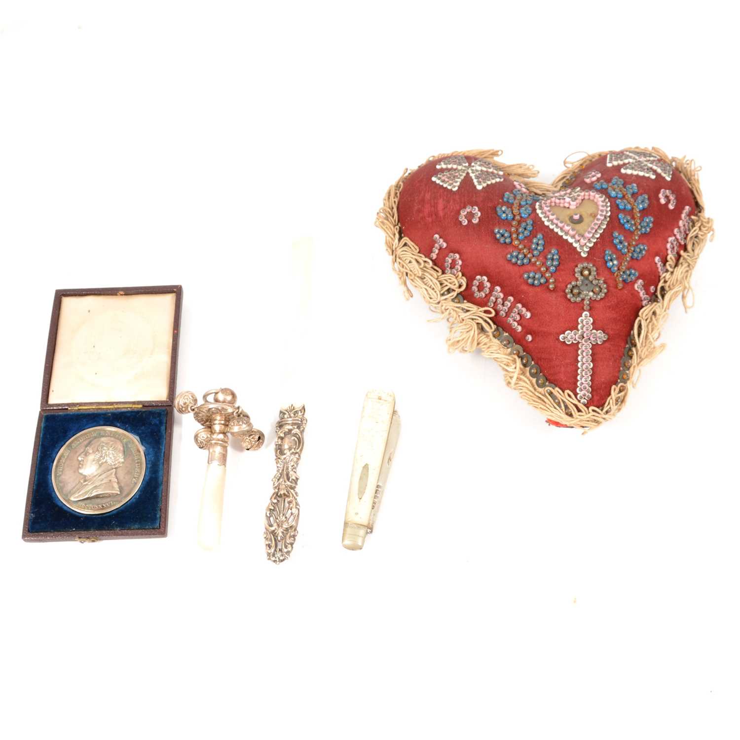 A heart shaped beaded pin cushion, Royal Horicultural Society medal, baby's rattle and other silver.