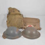 Two World War II tin helmets, khaki bags.