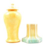 Ruskin Pottery - a yellow glaze lidded jar and two tone candlestick.
