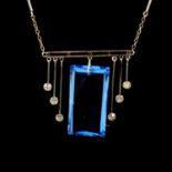 A blue paste crystal pendant and chain in the Art Deco style.