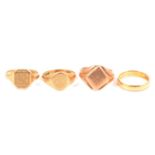 An 18 carat gold wedding ring and three gold signet rings.