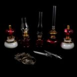 Collection of cranberry glass and brass oil lamps