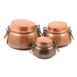 Three graduated Burmese copper cooking pots, with lids.