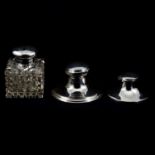 Two silver capstan inkwells and a large silver-mounted glass jar.