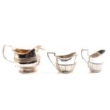 A George III silver milk jug, and two silver cream jugs,