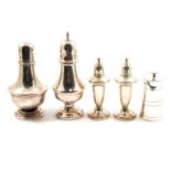 A silver urn shape pepper mill, two casters and pair of weighted peppers.