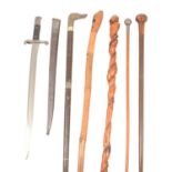 Collection of four walking sticks, a swagger stick and a bayonet
