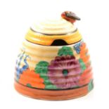 A Clarice Cliff Bizarre preserve/honey pot and cover in the Gayday pattern.