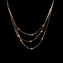 A yellow metal necklace, three strands to front with beads