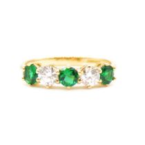 An emerald and diamond half hoop ring.