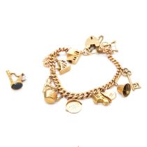 A gold charm bracelet with eleven charms and a bloodstone seal.