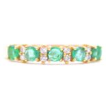 An emerald and diamond half eternity ring.