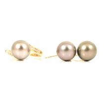 A modern cultured Tahitian pearl and diamond crossover ring and pair of earrings.
