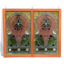 Two leaded and stained glass panels, in a hardwood frame,