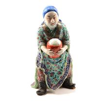 Chinese porcelain and polychrome decorated figure of a merchant