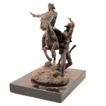 After Remington, a reproduction bronze group of a cowboy on horseback