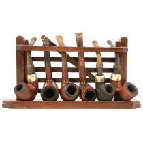 A five space pipe rack and collection of smokers pipes.