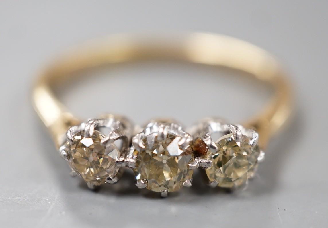 An 18ct and three stone diamond set ring, size P, gross weight 2.8 grams.