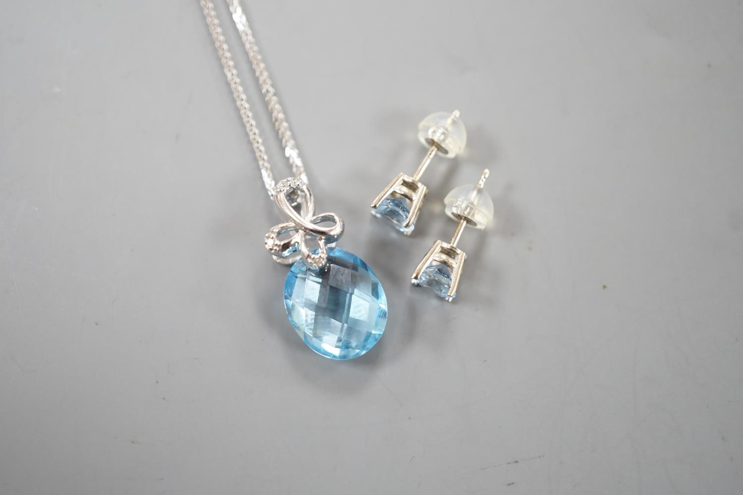 A modern 14k white metal, facetted pear cut blue topaz and diamond chip set pendant, 19mm, on a - Image 2 of 4