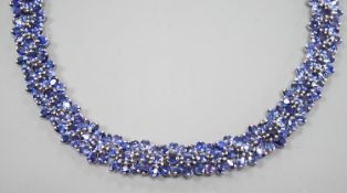 A continental base metal and synthetic sapphire? flower head cluster set necklace, approximately